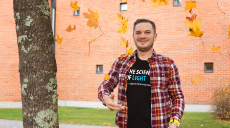 Young man outside, orange leaves around him.