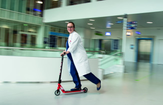 Milla-Maria Tauriainen kulkee potkulaudalla sairaalan aulassa