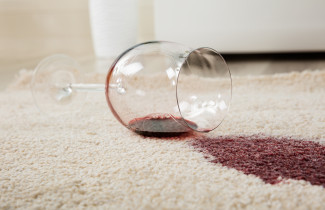 Red wine spilled from glass on carpet