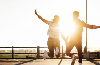 Kaksi nuorta hypää käsi kädessä ilmaan