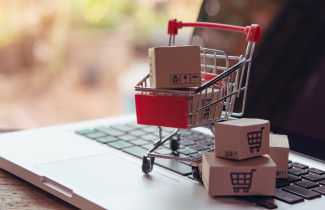 Ostoskärry ja paketteja tietokoneen näppäimistöllä