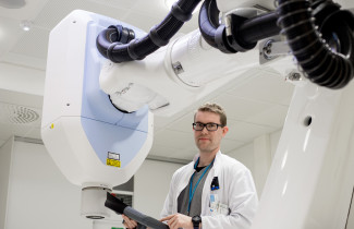 Mies työskentelee lääketieteellisen fysiikan laitteella.