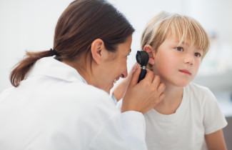 Lääkäri tutkii lapsen korvaa.