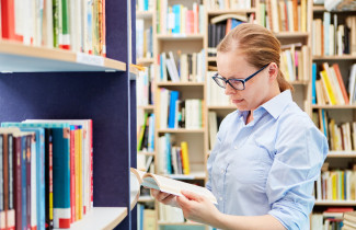 Woman reading a book in a library.
