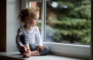 Lapsi katsoo ulos ikkunasta