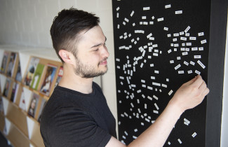 Young man playing with magnetic words.