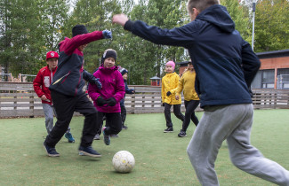 Oppilaat jalkapalloa pelaamassa.