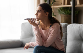 Woman using mobile phone&#039;s voice recognition.