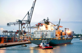 Kontteja lastataan tankkeriin satamassa.