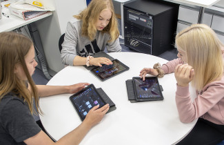 Oppilaat opiskelemassa iPadeilla.