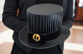 Henkilö pitelee tohtorinhattua