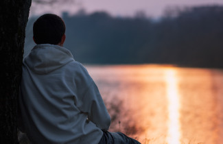 Lapsi istuu rannalla.