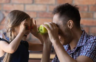Isä ja lapsi leikkimässä kasviksilla