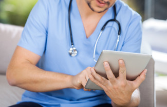 Sairaanhoitaja kirjaa tabletille.