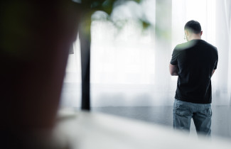 Henkilö katsoo alaspäin ikkunasta.