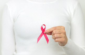 Roosa nauha kädessä.