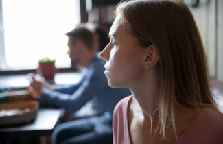 Henkilö on etääntynyt taustalla näkyvistä ihmisistä.