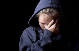 Nuori henkilö huppu päässä.