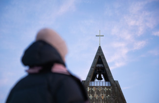 Henkilö kirkon edessä.