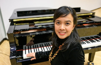 Dian Permatasari Suwandi in front of a piano.