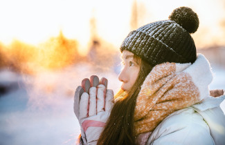 Student in winter outside with warm clothes, sun is shining