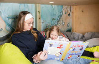 Varhaiskasvatuksen opiskelija lukemassa kirjaa lapselle.