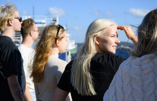 Uef-lähettiläitä Kuopion vierasvenesatamassa katsomassa järvelle päin aurinkoisessa säässä