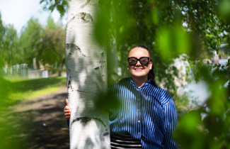 Ruotsin kielen opiskelija Riikka Kinnunen aurinkolasit päässään kesäisessä maisemassa