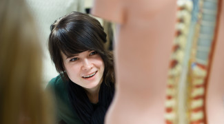 Woman studying a medical education anatomy model.