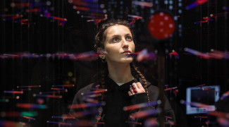 Henkilö punertavien valoheijastusten keskellä pimeässä