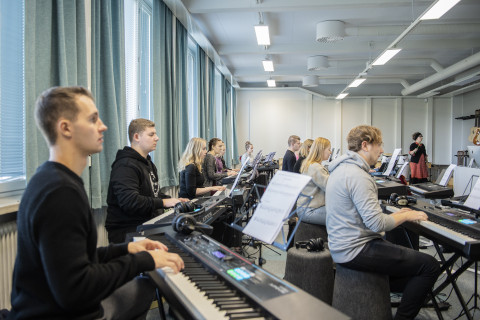 Opiskelijat soittavat pianoa