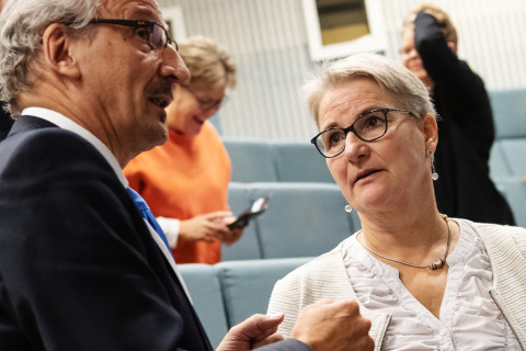 Mies ja nainen keskustelevat luentosalissa.