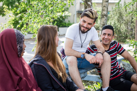 Henkilöitä keskustelemassa ulkona