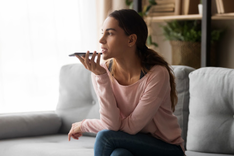 Woman using mobile phone&#039;s voice recognition.