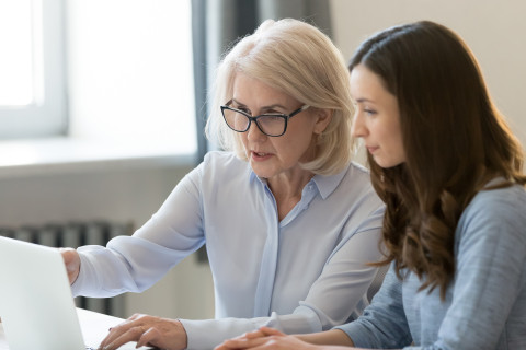 Vanhempi ja nuorempi nainen tietokoneella.