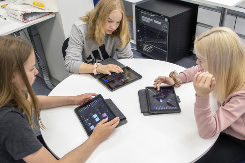 Oppilaat opiskelemassa iPadeilla.