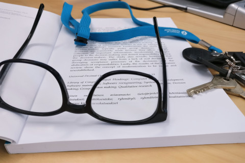 Silmälasit ja avaimet kirjan päällä.