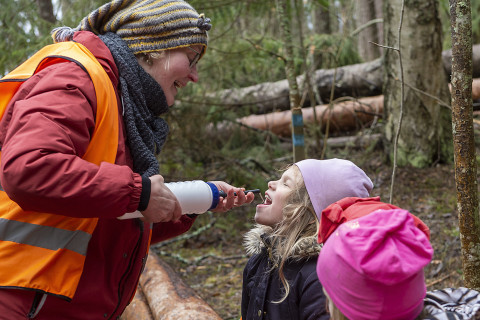 Opettaja antaa vettä lapselle.