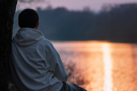 Lapsi istuu rannalla.