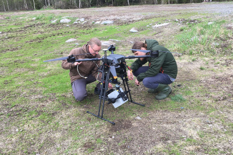 Tutkijat tarkastavat droonilentolaitetta.