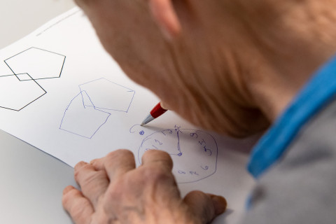 Elderly patient performing a drawing test.
