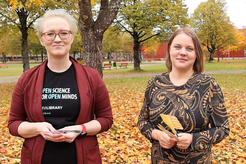 Kaksi kirjastoammattilaista syksyisessä puistossa.