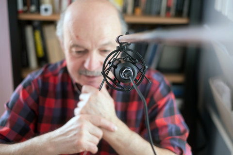 Vanha mies puhuu mikrofoniin.