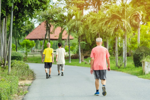 Elderly man walking in a park.