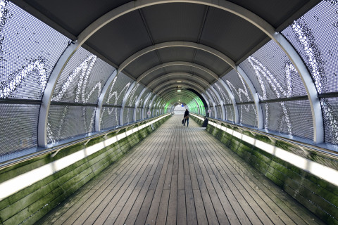 People walking in tunnel.
