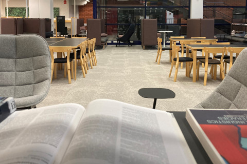 Kuopion kampuskirjaston tiloissa nojatuoleja ja työpöytiä.