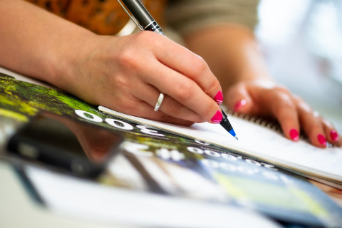 Nainen kirjoittaa muistiinpanoja.