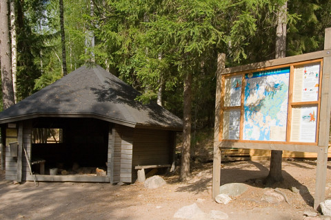 Kota ja opastetaulu metsässä.