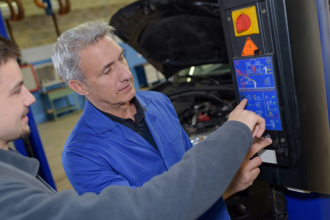 Miehet korjaamassa autoa.