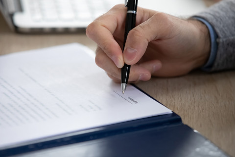 Lähikuva allekirjoittavasta kädestä.